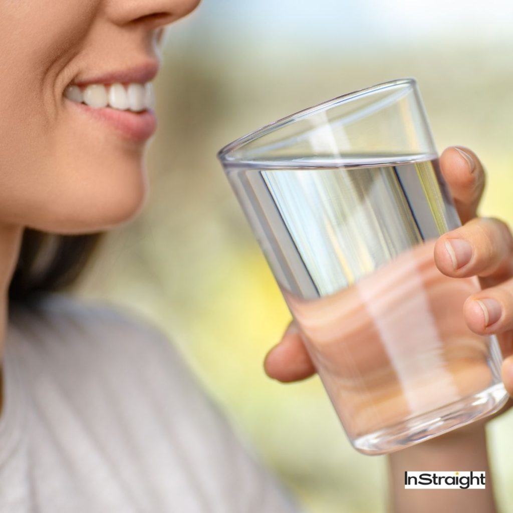 a woman drinking a glass of water